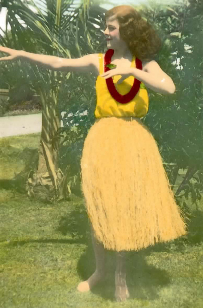Vintage image of Flora Komes in traditional hula skirt